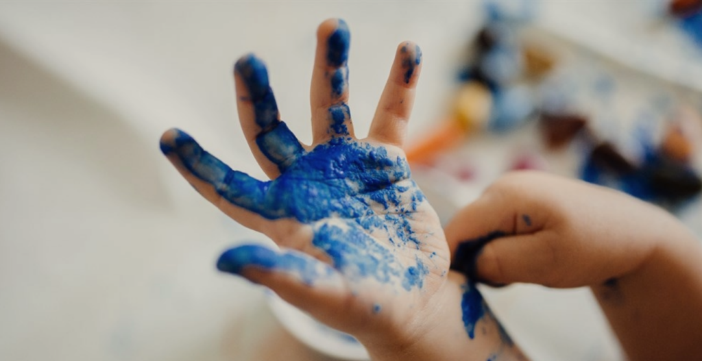 Kids hand covered in blue paint